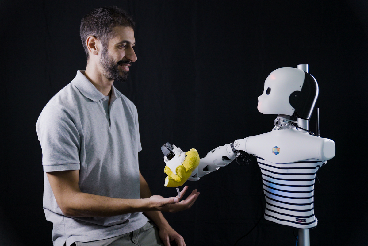 Marwen Belkaid interacts with a robot created by ETIS